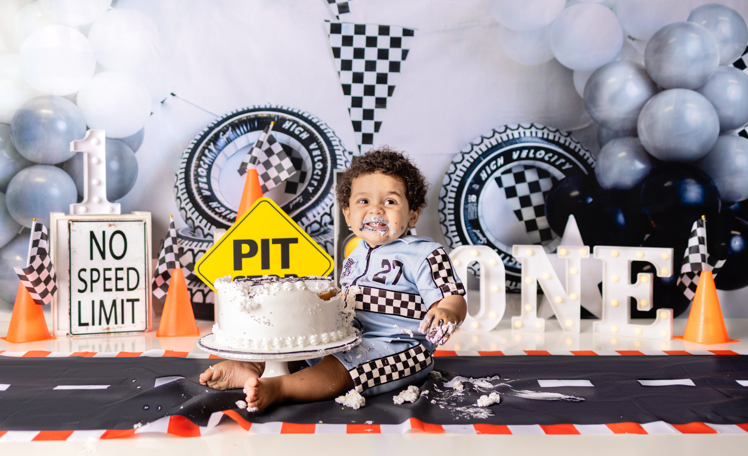 baby enjoying cake smash photoshoot with white frosting cake