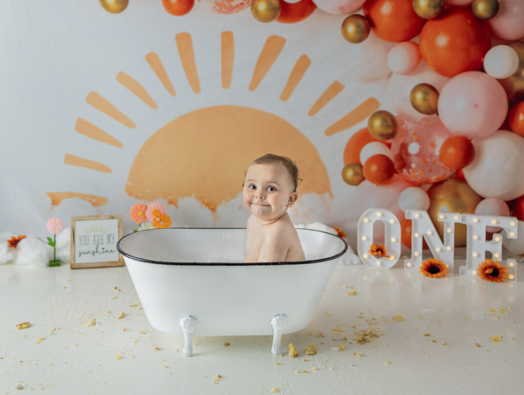 One-year-old girl enjoys a bubble bath after her cake smash session in Bergen County.