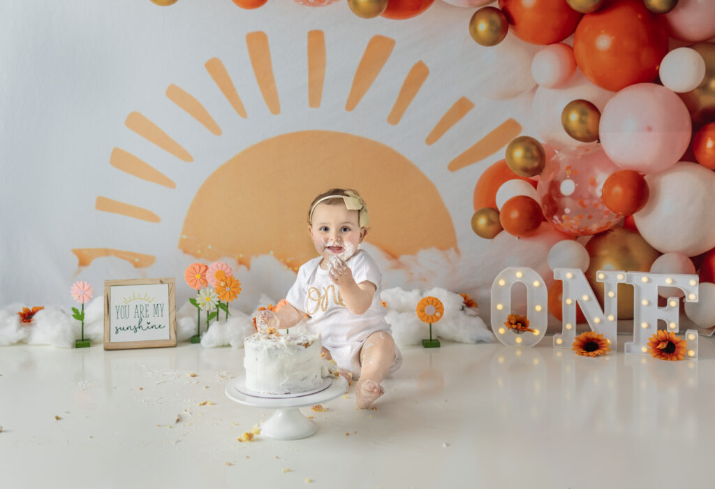 Baby girl enjoying cake during her first birthday cake smash session 