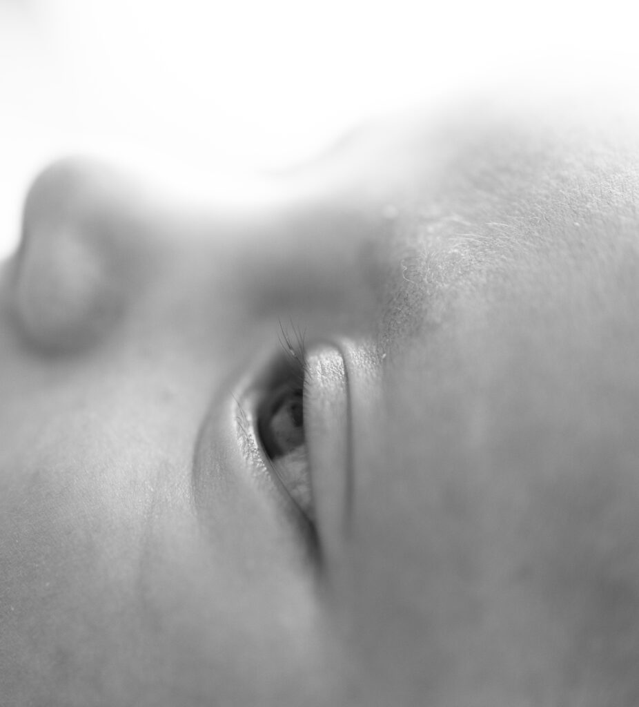 Bergen County, NJ newborn photographer captures a close-up of baby’s eye, highlighting tiny eyelashes and soft skin.